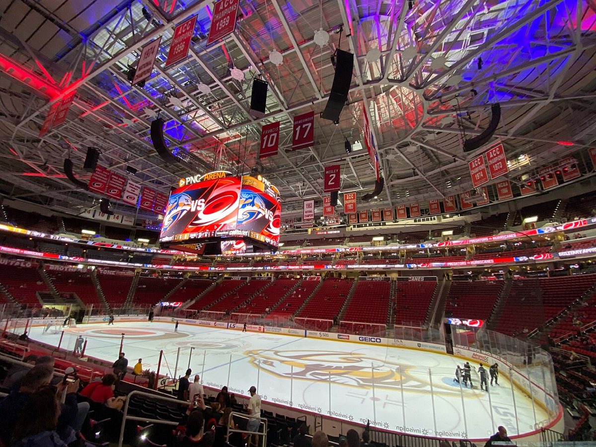 couple cheering together in the stands at a Carolina Hurricanes game at PNC Arena